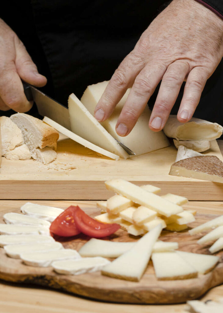 close-up-chef-cutting-cheese-wooden-board_Easy-Resize.com-1-731x1024 20/01 - Feliz dia do Queijo para você também!